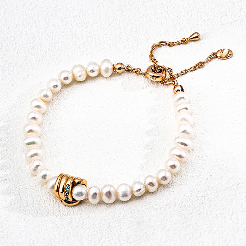 Close-up of a minimalist freshwater pearl bracelet with gold-plated clasp and zircon details, made of 925 silver.