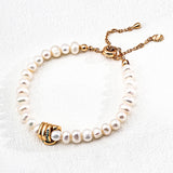 Close-up of a minimalist freshwater pearl bracelet with gold-plated clasp and zircon details, made of 925 silver.