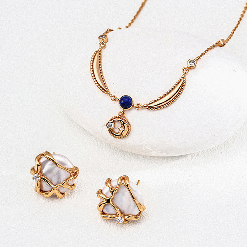 A pair of wavy sculpted gold S925 silver pearl earrings paired with a delicate layered necklace, presented on a minimalist white background for modern elegance.