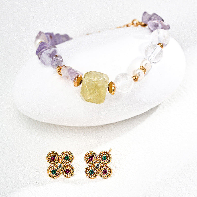 A pale yellow and purple crystal bracelet paired with vintage floral gold earrings, creating a whimsical and romantic accessory set.