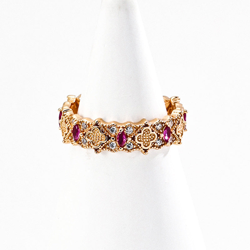 A gold-tone S925 silver ring with floral patterns, set with ruby-colored zircon and fine detailing.