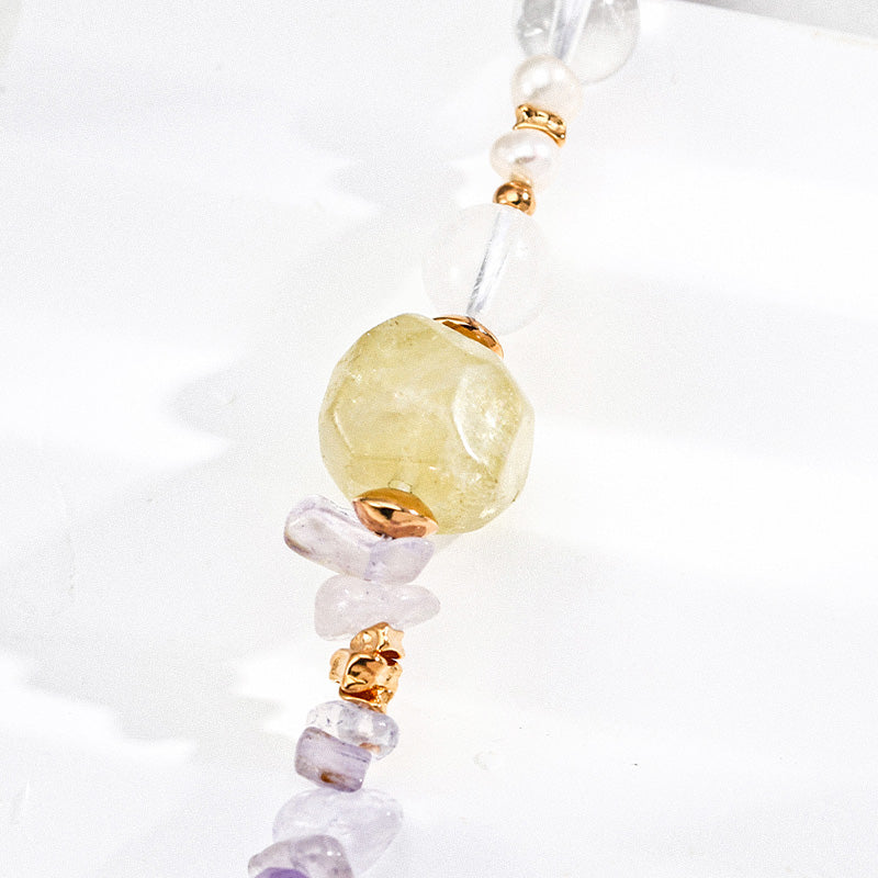 Close-up of a minimalist S925 silver bracelet with a faceted yellow crystal as the focal bead, accented by amethyst chips, pearls, and translucent white stones, reflecting soft light for a dreamy, luminous look.