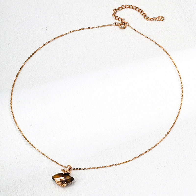 Full view of a dainty S925 silver chain necklace with a tiger's eye gemstone pendant in retro gold-toned wrapping, laid flat against a white background.