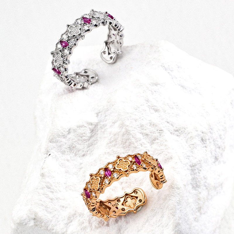 Two S925 silver rings, one gold and one silver, with ornate floral details and vivid zircon stones.