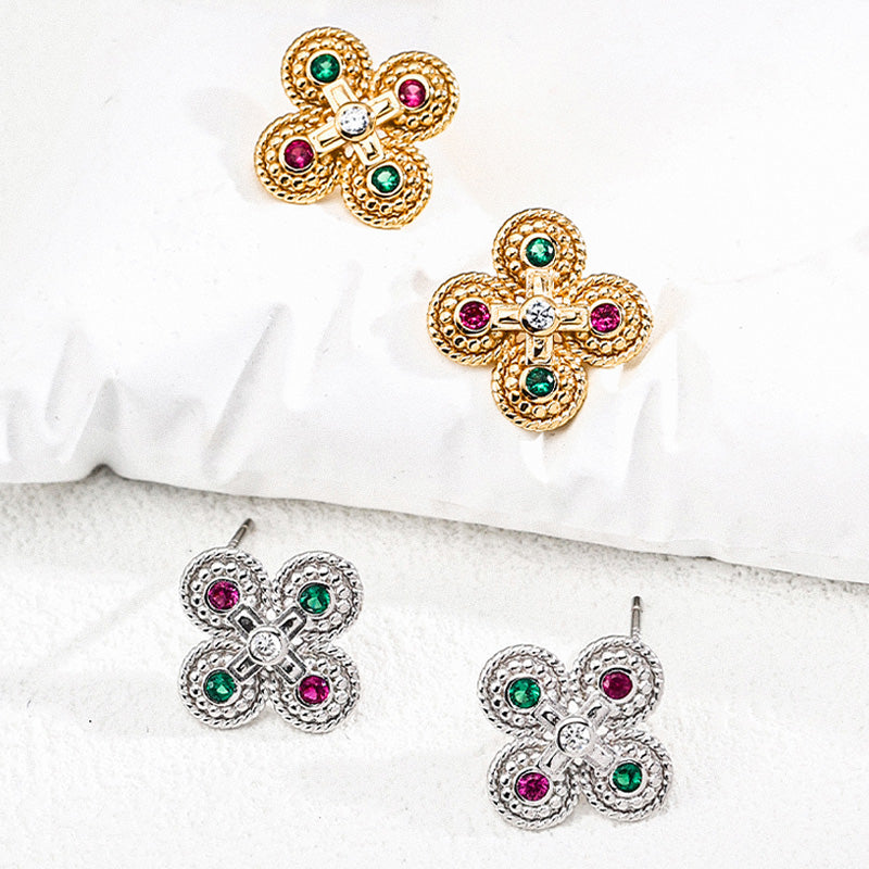 Collection of both gold and silver vintage-style zircon earrings with intricate textures and gemstone accents, displayed on soft white surfaces.