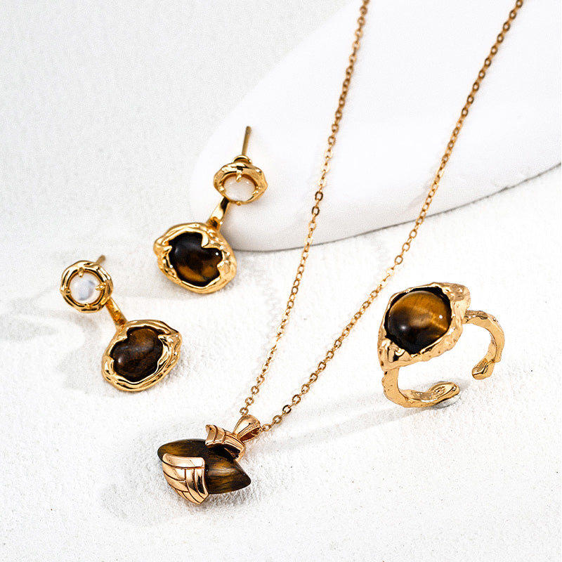 Artistic composition of matching tiger's eye jewelry set including gold-framed earrings, an open ring, and a pendant necklace, all crafted in vintage S925 silver.