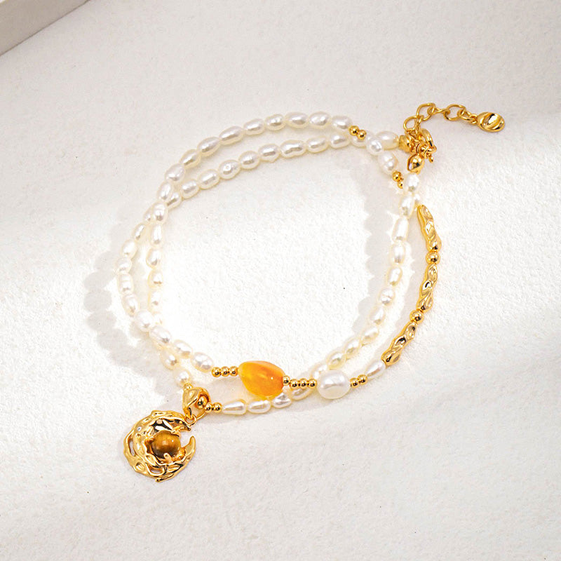 Delicately crafted freshwater pearl Pendant featuring an integrated tiger's eye, accented with a vibrant orange agate and golden detailing, blending natural elegance with artistic design.