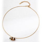 Flat-lay image of the S925 silver necklace featuring a faceted double-pointed tiger’s eye pendant held in a gold-plated frame, displayed on a soft white background with an adjustable clasp.