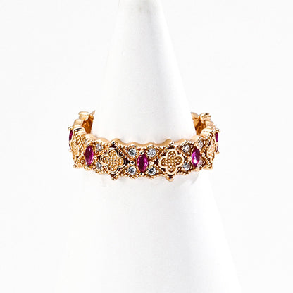 A gold-tone S925 silver ring with floral patterns, set with ruby-colored zircon and fine detailing.