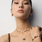 A model wears the S925 sterling silver geometric tiger’s eye pendant necklace layered with a pearl beaded choker and matching bracelet, showcasing a warm, earthy-toned jewelry styling.