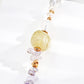 Close-up of a minimalist S925 silver bracelet with a faceted yellow crystal as the focal bead, accented by amethyst chips, pearls, and translucent white stones, reflecting soft light for a dreamy, luminous look.