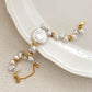 Flat lay of Luminique’s keshi baroque pearl bracelet featuring a round central disc pearl, gold-plated silver clasp, and asymmetrical freshwater pearls.