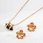 The tiger’s eye pendant necklace is displayed alongside a pair of textured gold flower earrings, arranged on a neutral surface to highlight their warm tones and natural charm.