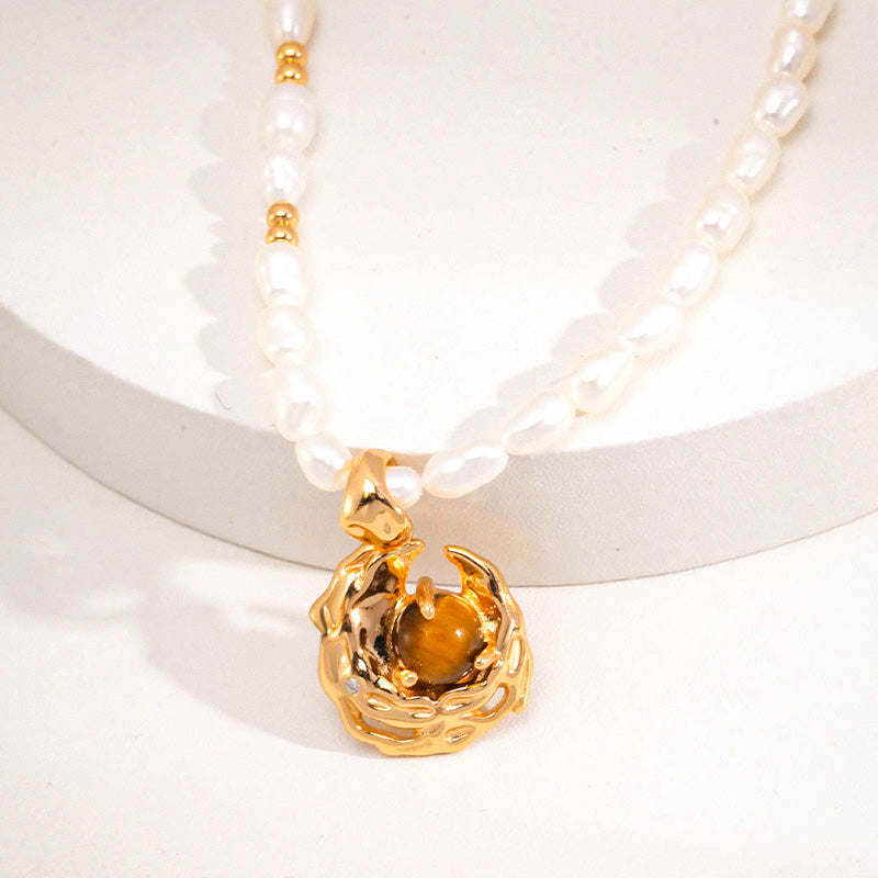 Elegant freshwater pearl necklace featuring a gold-finished 925 silver pendant with a rich tiger's eye gemstone, symbolizing strength and warmth.