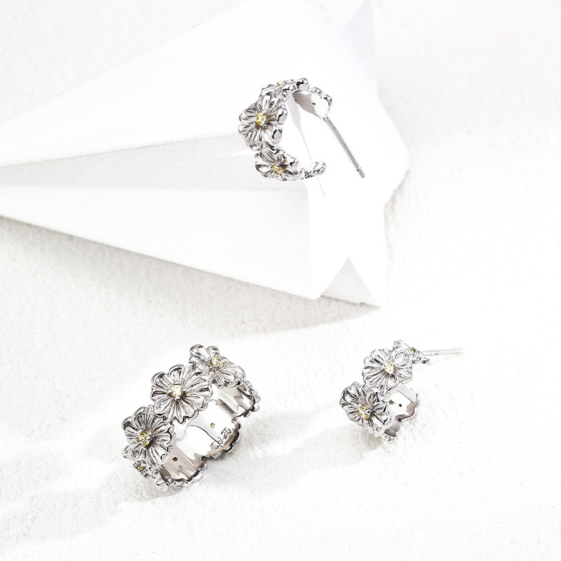 Coordinated floral jewelry set in silver tone with yellow zircons, including hoop earrings and a matching ring.