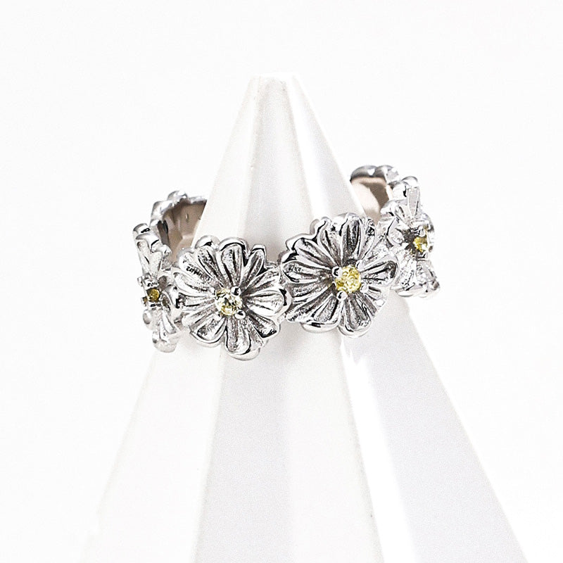 S925 silver floral ring featuring textured petals and soft yellow zircon stones at the center of each bloom.