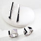 A contemporary jewelry trio featuring silver-tone S925 earrings with architectural black enamel detailing, paired with two matching geometric rings—one with a bold pyramid structure and the other with clean segmented curves—styled on a smooth stone surface for a sleek, modern look.