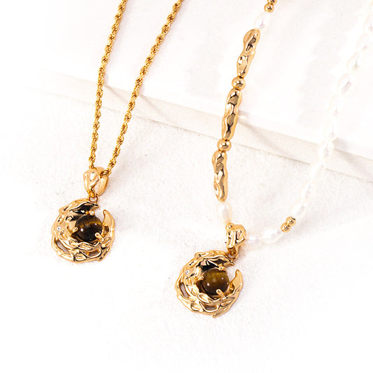 A refined jewelry set showcasing a tiger's eye pendant on two distinct necklaces: one with textured gold chain, the other with freshwater pearls and golden accents, blending natural beauty with artistic craftsmanship.