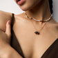 Close-up of a model's collarbone area wearing the tiger’s eye pendant necklace layered with a pearl bead choker, highlighting the earthy contrast and minimalistic elegance.